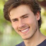 young man with a beautiful smile after getting crowns for his teeth