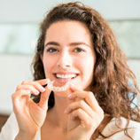 woman trying on an invisalign mouthguard